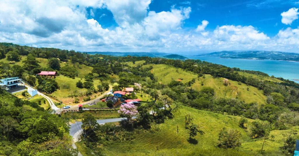 an image of Santa Elena in Costa Rica from above, With lush green hills and the ocean in the distance.
