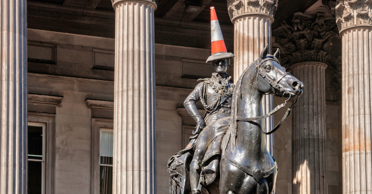 The famous Duke of Wellington statue with the traffic cone on his head in Glasgow city centre. The statue is the duke sitting atop his horse, looking regal, and there is the neon orange and while traffic cone right on top of his head. A must see on any Glasgow itinerary!